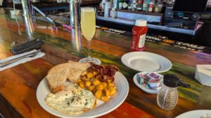 Early bird breakfast plate with eggs, bacon, home fries, and a mimosa at Rams Head Southernmost in Key West