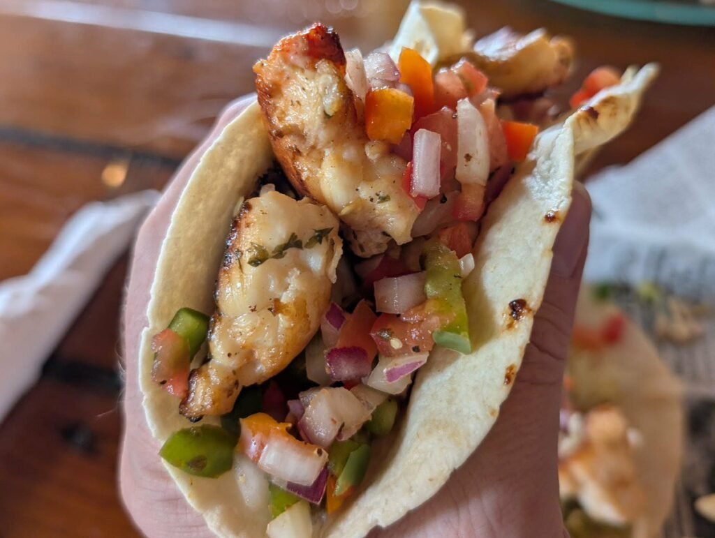 Holding a lobster taco topped with pico de gallo at Hogfish Bar and Grill in Key West