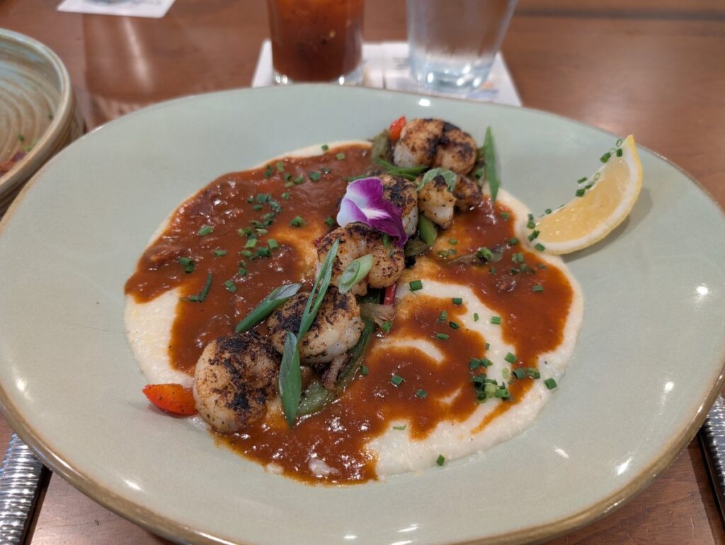 royal red shrimp and grits with sweet tomato andouille sauce and cheddar scallion grits